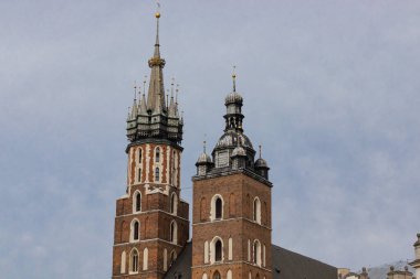 Bu yüksek çözünürlüklü resim Polonya 'nın Krakow kentindeki St. Marys Bazilikası' nın ikonik kulelerini gösteriyor. Kırmızı tuğla cephesi, gotik detaylar, ve asırlık kulelerin altını çizmek