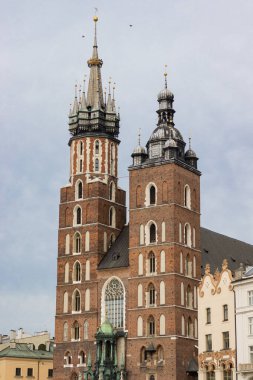 Bu yüksek çözünürlüklü resim Polonya 'nın Krakow kentindeki St. Marys Bazilikası' nın ikonik kulelerini gösteriyor. Kırmızı tuğla cephesi, gotik detaylar, ve asırlık kulelerin altını çizmek
