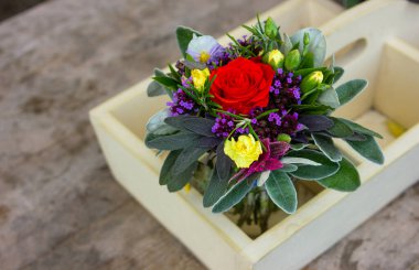 Ortasında kırmızı bir gül olan güzel bir buket bahçe çiçeği. Kırsal çiçek düzenlemesi