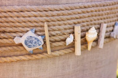 Small decorative sea figures of turtle and shells on a flower pot. Garden decor and design.