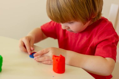 Sevimli sarışın çocuk, renkli plastikten heykeller. çocuk eğlencesi, eğlence, aktiviteler, eğitim oyunları.