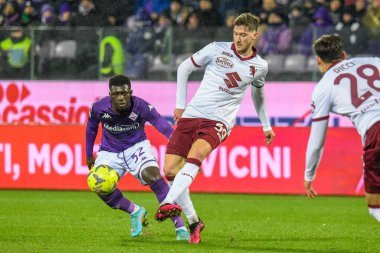 Torino's Aleksey Miranchuk hampered by Fiorentina's Alfred Duncan during italian soccer Serie A match ACF Fiorentina vs Torino FC at the Artemio Franchi stadium in Florence, Italy, January 21, 2023 - Credit: Fabio Fagiolin