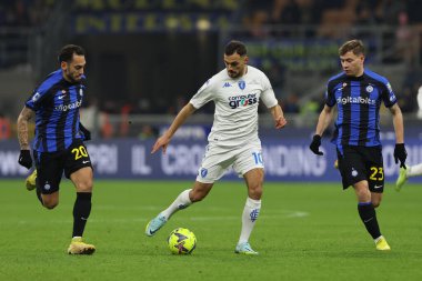 Nedim Bajrami of Empoli FC competes for the ball with Hakan Calhanoglu of FC Internazionale and Nicolo Barella of FC Internazionale during Serie A 2022/23 football match between FC Internazionale and Empoli FC at Giuseppe Meazza Stadium, Milan, Italy