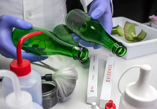 警方专家从犯罪实验室的玻璃瓶中提取血液样本 — 图库照片