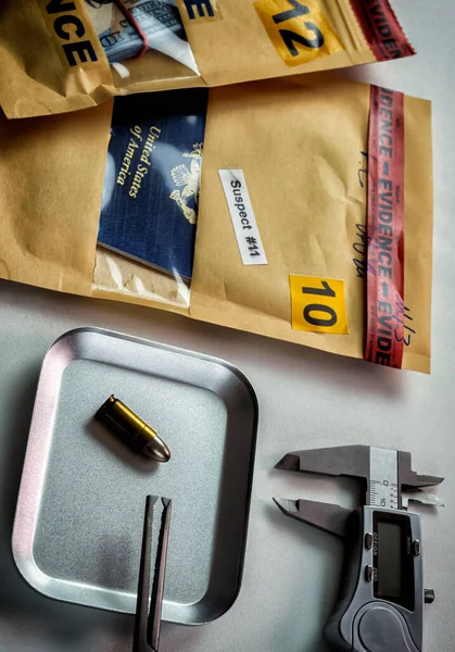 US passport next to bullet in evidence bags in crime lab, concept image