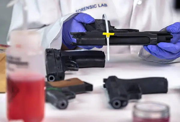 Close up of forensic science evidence box containing gun from crime scene, conceptual image