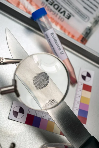 Police investigation of fingerprint on a knife, concept image