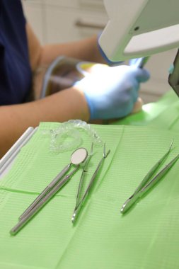 Modern bir diş muayenehanesi için ekipman, genç bir kızın dişlerinde görünmez kaplamalar.