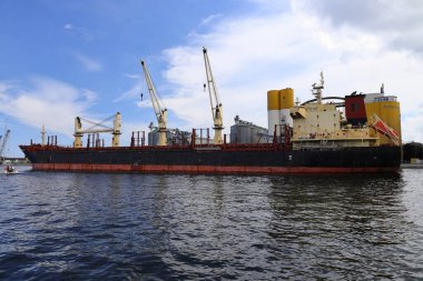 Gemi limana demirlemiş, tersanenin yanındaki liman altyapısının yanında.