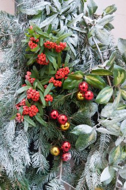 Yeşil yapraklı ve kırmızı mücevherli Noel dekorasyonunun ön görüntüsü