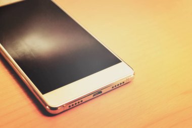 Akıllı Telefonun ayrıntıları, nesne ahşap sarı arkaplanda