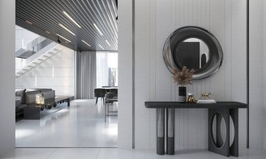 Minimalist mobilyaların ve çağdaş merdivenlerin yer aldığı gösterişli, modern bir iç mekan. Vazo ve dekoratif elementlere sahip şık bir konsol masası dairesel ayna ve modern ışıklandırmayla işaretlenmiş açık alanı geliştirir..