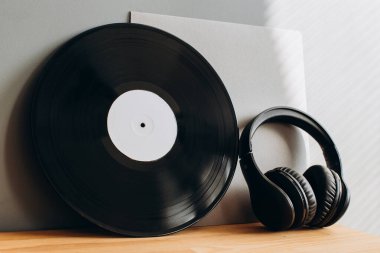 Gri arka planda kağıt zarf ve kulaklıkla plaklar. Model