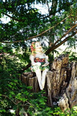 German traditional porcelain figurine of a doll sitting on a stomp  