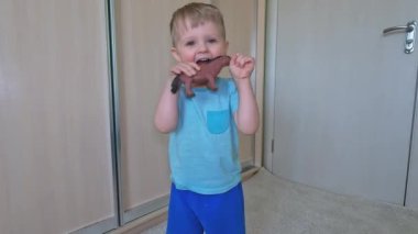 Neşeli küçük çocuk lastik oyuncağını geriyor ve gülüyor. Çocuklarda iyi motor becerilerin gelişimi. Kopyalama alanı - şımartma, eğlence, oyun, eğlence, güç, kötü davranış, eğitim kavramı