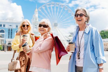 Güzel, mutlu, son sınıf kadınları şehir merkezinde buluşup alışveriş yapıyorlar güzel ve neşeli yaşlı kadın yetişkin insanlar kaynaşıyor ve dışarıda eğleniyorlar.