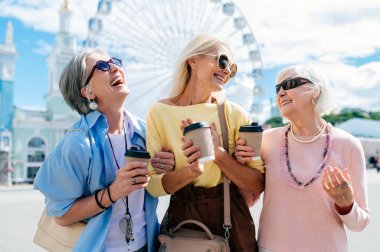 Güzel, mutlu, son sınıf kadınları şehir merkezinde buluşup alışveriş yapıyorlar güzel ve neşeli yaşlı kadın yetişkin insanlar kaynaşıyor ve dışarıda eğleniyorlar.