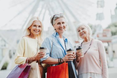 Güzel, mutlu, son sınıf kadınları şehir merkezinde buluşup alışveriş yapıyorlar güzel ve neşeli yaşlı kadın yetişkin insanlar kaynaşıyor ve dışarıda eğleniyorlar.