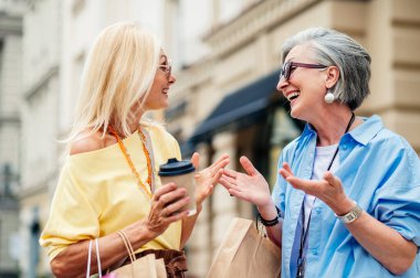 Güzel, mutlu, son sınıf kadınları şehir merkezinde buluşup alışveriş yapıyorlar güzel ve neşeli yaşlı kadın yetişkin insanlar kaynaşıyor ve dışarıda eğleniyorlar.