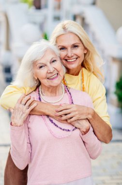 Bir grup güzel ve mutlu yetişkin kadın dışarıda buluşuyor ve şehirde buluşuyorlar şık, yaşlı, olgun insanlar sosyal bir araya geliyor ve bir kafede eğleniyorlar.