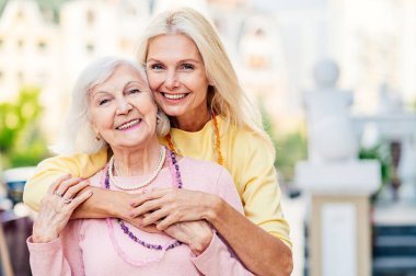 Bir grup güzel ve mutlu yetişkin kadın dışarıda buluşuyor ve şehirde buluşuyorlar şık, yaşlı, olgun insanlar sosyal bir araya geliyor ve bir kafede eğleniyorlar.