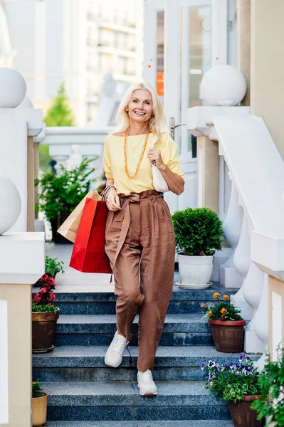 stock image Beautiful and happy senior adult woman shopping in the city - Stylish fashionable old mature people shopping in clothing store