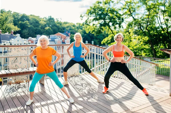 一群漂亮的运动健美的老年女子在户外训练 成熟的成年人老朋友在公园里做健身锻炼以保持健康和健康 — 图库照片