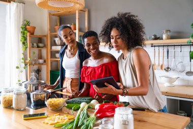 Mutlu güzel İspanyol asıllı Güney Amerikalı ve siyahi kadınlar kapalı alanda tanışıp eğleniyorlar - siyahi kadınların en iyi arkadaşları birlikte vakit geçiriyorlar, ev hayatı, boş zaman, arkadaşlık ve birliktelik kavramları