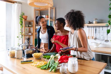 Mutlu güzel İspanyol asıllı Güney Amerikalı ve siyahi kadınlar kapalı alanda tanışıp eğleniyorlar - siyahi kadınların en iyi arkadaşları birlikte vakit geçiriyorlar, ev hayatı, boş zaman, arkadaşlık ve birliktelik kavramları