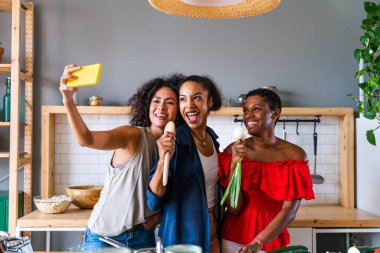 Mutlu güzel İspanyol asıllı Güney Amerikalı ve siyahi kadınlar kapalı alanda tanışıp eğleniyorlar - siyahi kadınların en iyi arkadaşları birlikte vakit geçiriyorlar, ev hayatı, boş zaman, arkadaşlık ve birliktelik kavramları