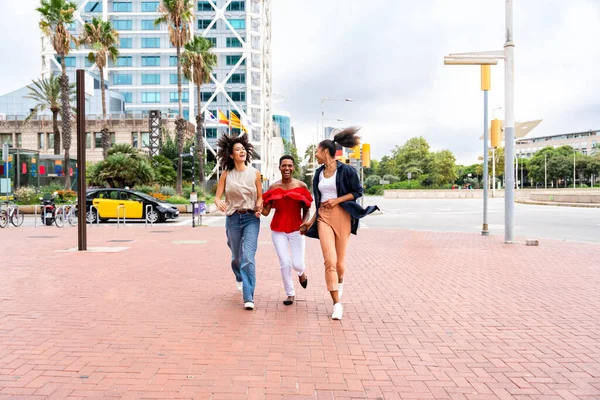 幸せな美しいヒスパニック系南アメリカ人と黒人女性が屋外で会い 楽しみを持っています 黒人の大人の女性の友人は一緒に時間を過ごし 買い物のために街を歩く — ストック写真