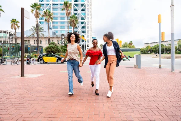 幸せな美しいヒスパニック系南アメリカ人と黒人女性が屋外で会い 楽しみを持っています 黒人の大人の女性の友人は一緒に時間を過ごし 買い物のために街を歩く — ストック写真
