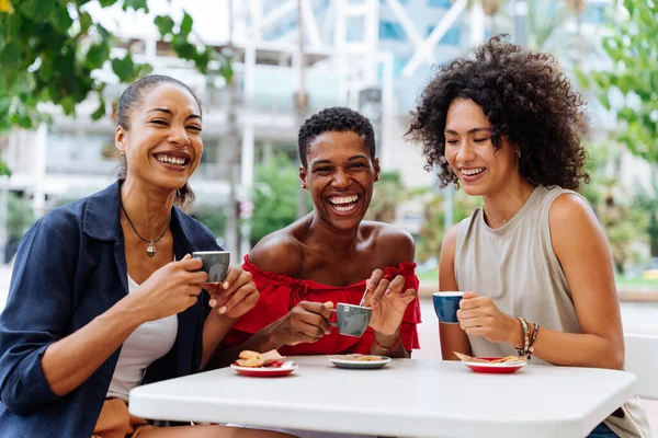 幸せな美しいヒスパニック系南アメリカ人と黒の女性が屋外で会うと楽しい 黒の大人の女性の友人が一緒にバーカフェに座って時間を過ごす — ストック写真