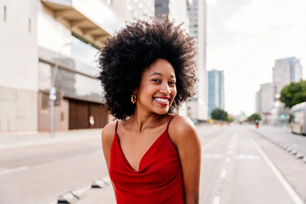 Beautiful young happy african woman with afro curly hairstyle strolling in the city - Cheerful black student walking on the streets