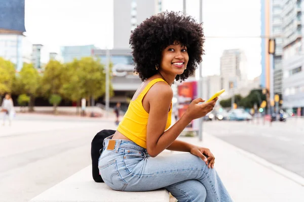 美しい若いです幸せなアフリカの女性とともにアフロ巻きヘアスタイル街を歩く 陽気な黒学生の女の子が通りを歩く — ストック写真