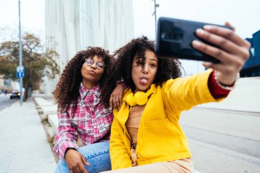 Genç mutlu kadınlar dışarıda eğleniyor, gülüyor ve keyiflerini paylaşıyorlar. Genç arkadaşlar Barcelona 'da dışarıda vakit geçiriyorlar