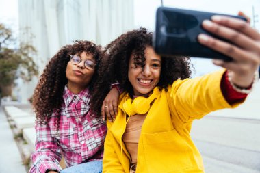 Genç mutlu kadınlar dışarıda eğleniyor, gülüyor ve keyiflerini paylaşıyorlar. Genç arkadaşlar Barcelona 'da dışarıda vakit geçiriyorlar