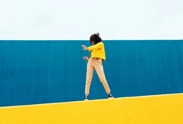 여자가 야외에서 즐겁게 놉니다 대들은 지역의 노란색 파란색 지역에서 스마트폰 — 스톡 사진