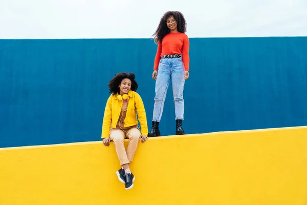 Νεαρές Χαρούμενες Γυναίκες Ποζάρουν Χρωματιστούς Μπλε Και Κίτρινους Τοίχους Έφηβη — Φωτογραφία Αρχείου