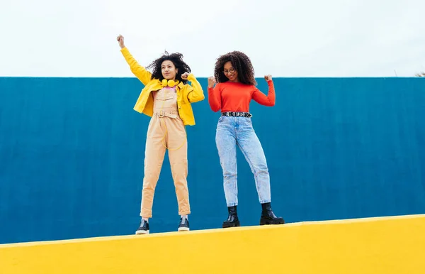 Genç Mutlu Kadınlar Mavi Sarı Renkli Duvarlarda Poz Veriyorlar Genç — Stok fotoğraf
