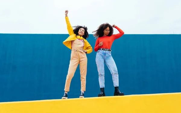 Jonge Vrolijke Vrouwen Poseren Gekleurde Blauw Geel Gekleurde Muren Tieners — Stockfoto