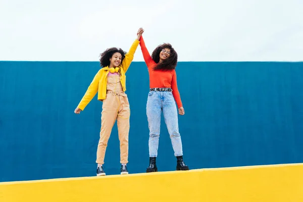 Jonge Vrolijke Vrouwen Poseren Gekleurde Blauw Geel Gekleurde Muren Tieners — Stockfoto