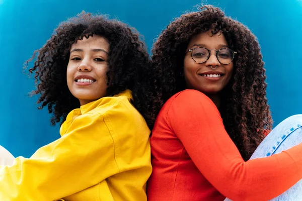 Genç Mutlu Kadınlar Mavi Sarı Renkli Duvarlarda Poz Veriyorlar Genç — Stok fotoğraf