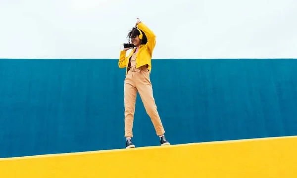 여자가 야외에서 즐겁게 놉니다 대들은 지역의 노란색 파란색 지역에서 스마트폰 — 스톡 사진