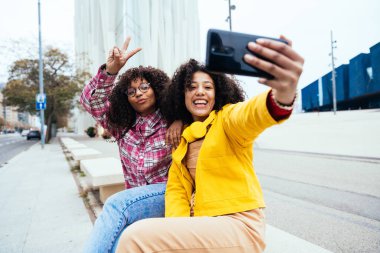 Genç mutlu kadınlar dışarıda eğleniyor, gülüyor ve keyiflerini paylaşıyorlar. Genç arkadaşlar Barcelona 'da dışarıda vakit geçiriyorlar