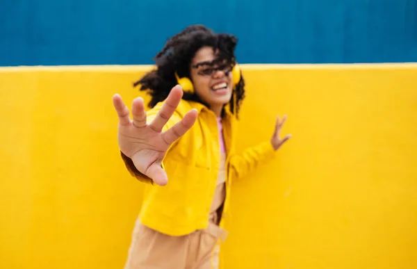 年轻快乐的女人跳舞 在户外玩得开心 在一个黄色和蓝色的现代城市地区 青少年们正在用智能手机和耳机听音乐 — 图库照片