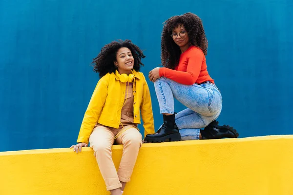 Jeunes Femmes Heureuses Posant Sur Des Murs Colorés Bleus Jaunes — Photo