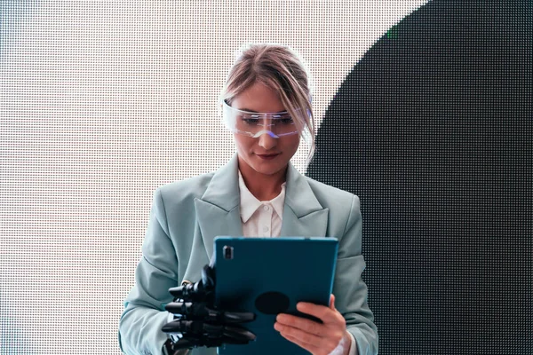 business woman with cyborg bionic arm and augmented reality visor. Representation of the future that will include human being and tech parts - cyberpunk look