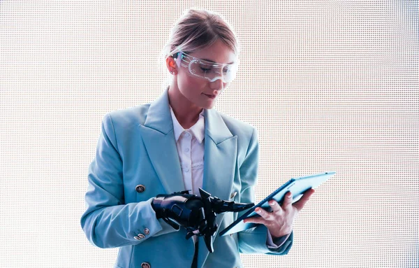 business woman with cyborg bionic arm and augmented reality visor. Representation of the future that will include human being and tech parts - cyberpunk look