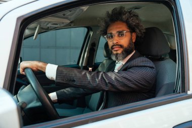 Genç bir girişimcinin, teknoloji ve yeşil enerji ile ilgili başarılı girişimcilik işinde çalışacağına dair sinematik ve hikaye anlatımı. Arabasını kullanan bir iş adamı.